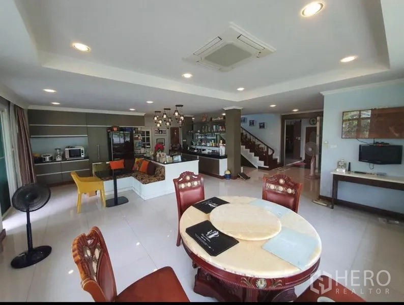 Detached House for sale in Sai Mai, Bangkok - Open-plan living and dining room with recessed lighting, staircase and bar counter.