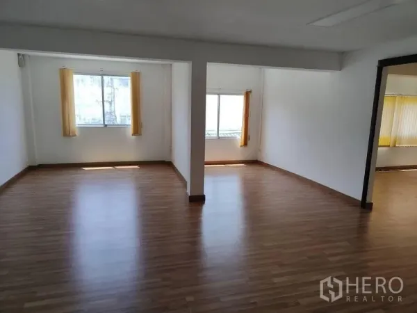Factory for sale in Sai Noi, Nonthaburi - Spacious office area with windows and yellow blinds on laminate flooring.