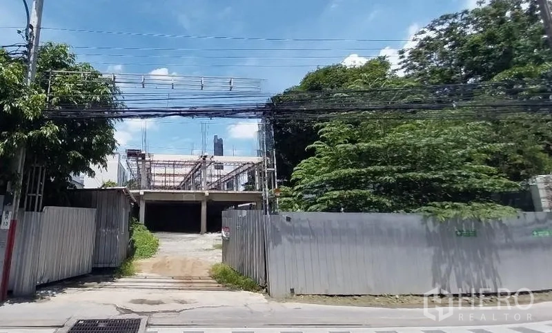 ที่ดิน ให้เช่าในKhlong Toei, Bangkok - มุมมองด้านหน้าแปลงพัฒนา ประตูรั้วกว้าง โครงสร้างบางส่วน และสายไฟเหนือศีรษะ ใกล้ถนนสุขุมวิท