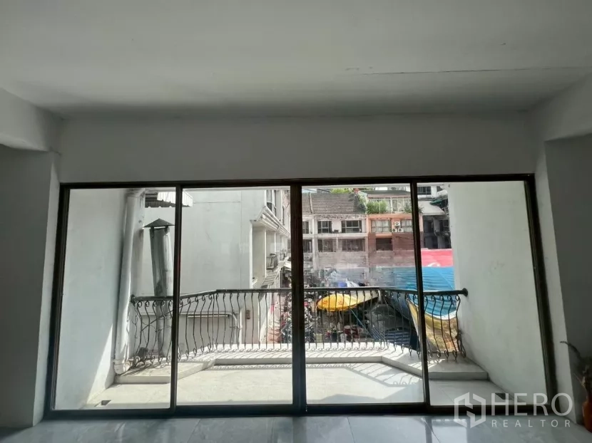 Retail Space for rent in Pathum Wan, Bangkok - Sliding glass doors opening to a small balcony with wrought-iron railing and street view.