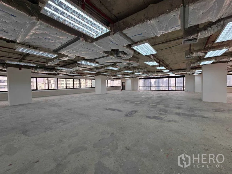 Office Space for rent in Bang Rak, Bangkok - Open-plan office interior with wraparound windows and Bangkok skyline views.