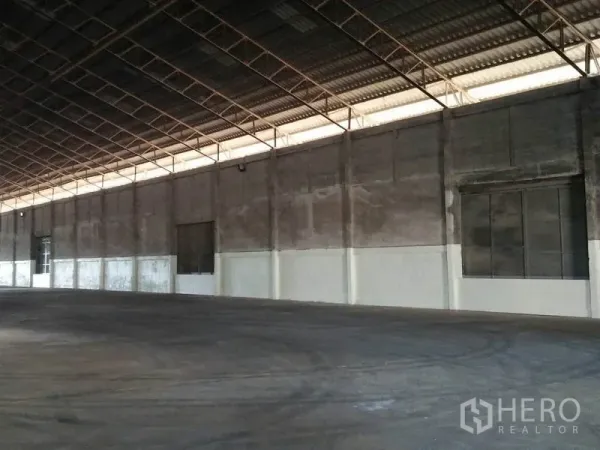 คลังสินค้า ให้เช่าในPathum Thani - ผนังด้านข้างโกดัง หลังคาสูง พื้นคอนกรีต มีช่องเปิดและประตูบานใหญ่ตลอดแนว