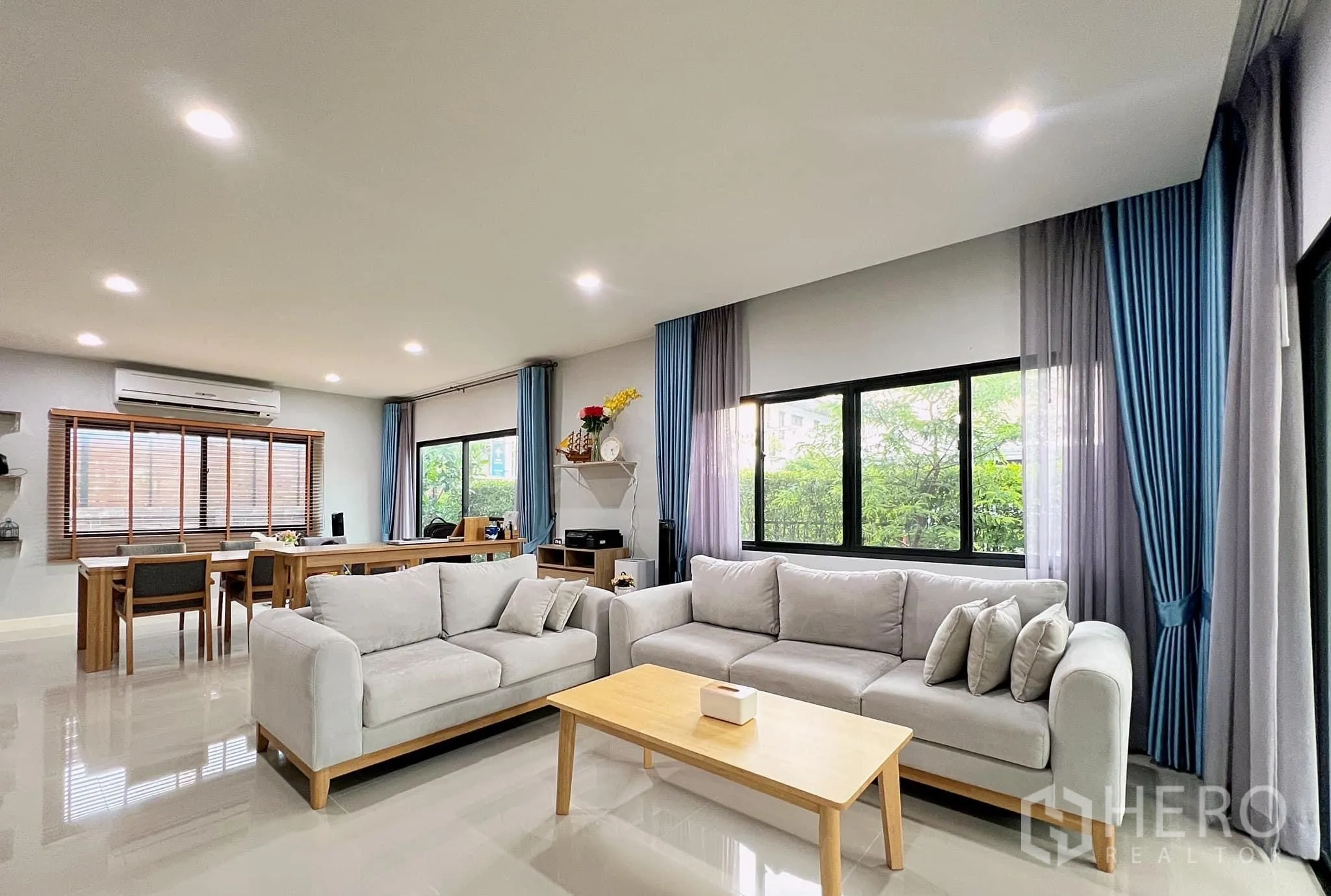 Detached House for rent or sale in Lam Luk Ka, Pathum Thani - Airy lounge with two sofas, coffee table and greenery outside the windows.