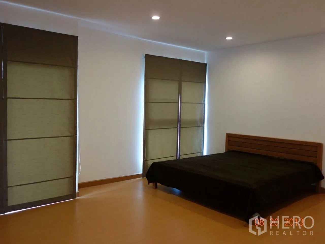 Townhouse for rent or sale in Suan Luang, Bangkok - Large bedroom with recessed lighting, blinds and a platform bed.