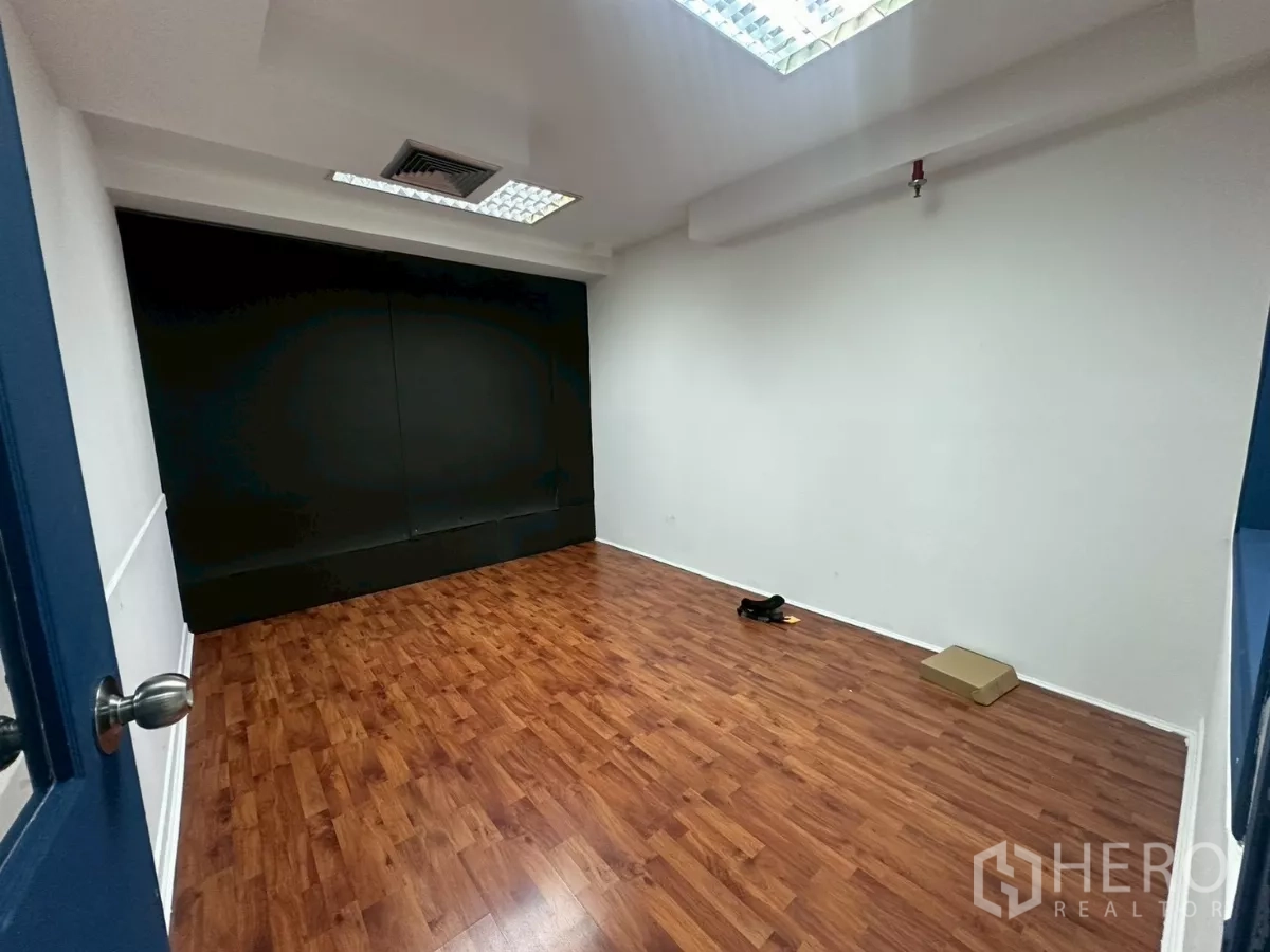 Office Space for rent in Khlong Toei, Bangkok - Workroom with wood floor and a dark acoustic wall, suitable for studio use.