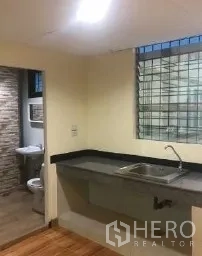Office Space for rent in Bang Rak, Bangkok - Kitchenette with sink and countertop adjacent to a tiled bathroom.