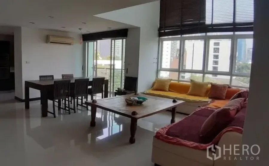 公寓 出租在Watthana, Bangkok - 明亮的开放式客餐厅，超大窗户与城市景观，设有窗边座位。