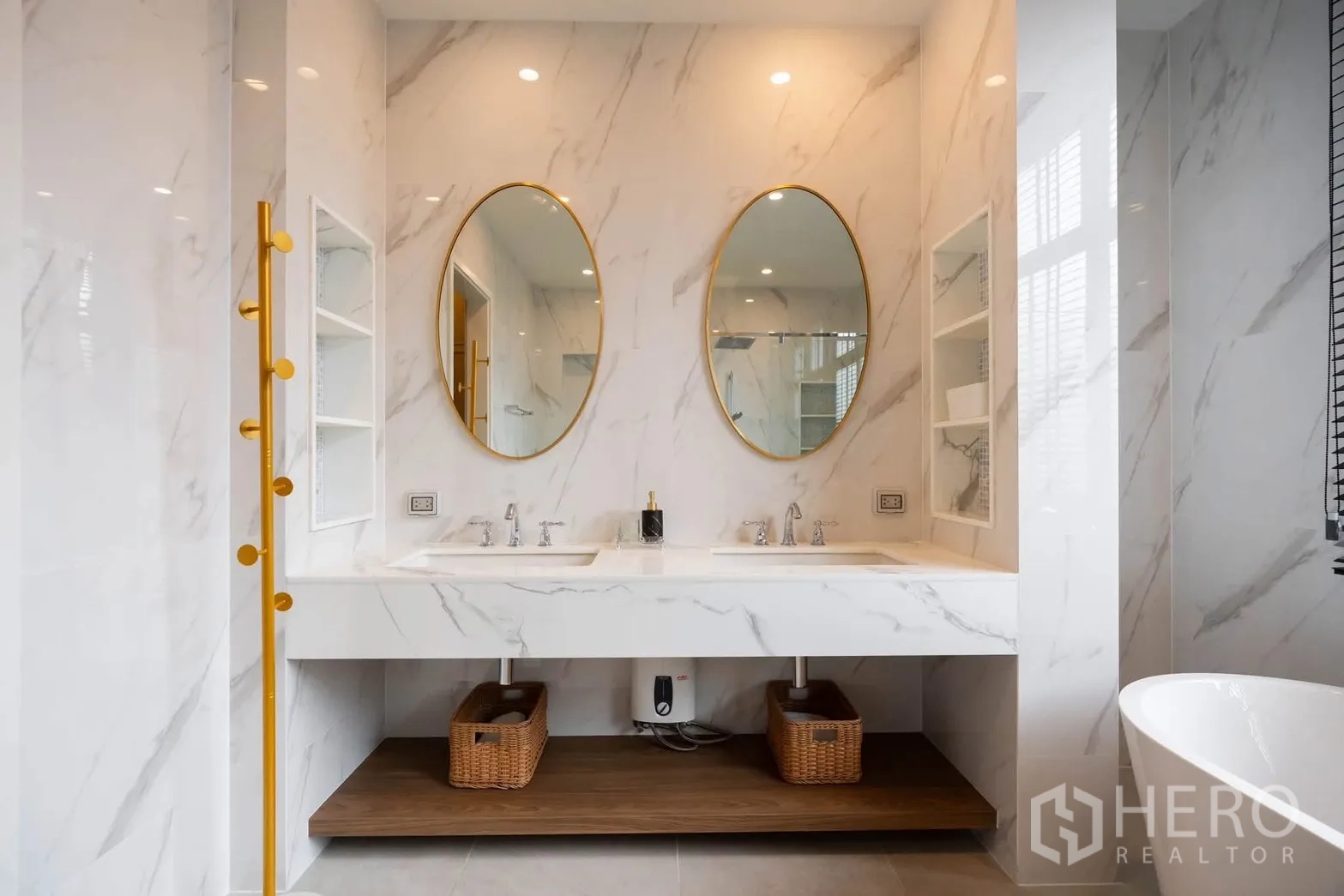 Detached House for rent or sale in Bang Kapi, Bangkok - Marble-look bathroom with double vanity and oval mirrors with gold frames.