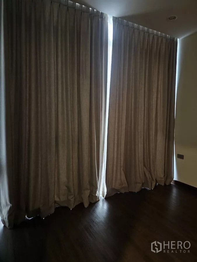 公寓 出租在Watthana, Bangkok - 卧室拉上遮光窗帘，落地窗与木地板质感温暖。