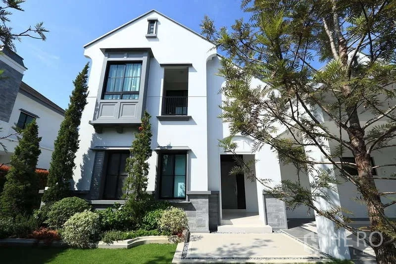 Detached House for rent in Saphan Sung, Bangkok - Two-story house facade with bay window, small balcony and trimmed greenery.