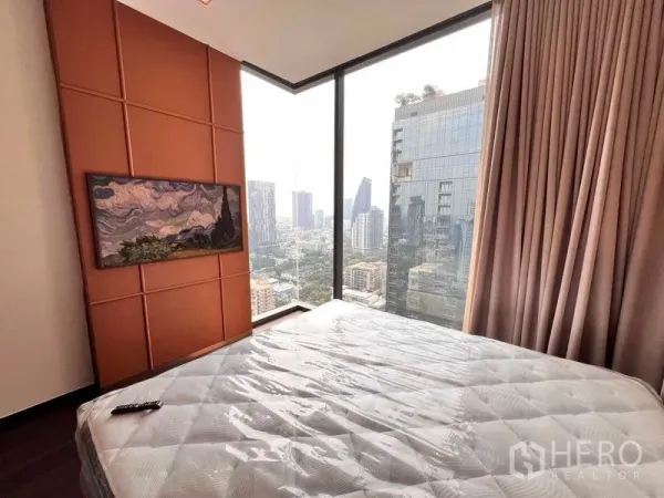 Condominium for rent in Watthana, Bangkok - Corner bedroom with floor-to-ceiling windows and Bangkok skyline view.