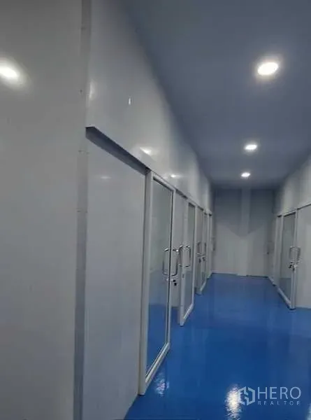 工厂 出租在Lam Luk Ka, Pathum Thani - 长走廊配多扇玻璃门，分隔多个工作空间，照明充足。