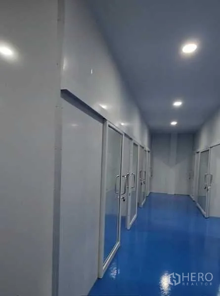 工厂 出租在Lam Luk Ka, Pathum Thani - 长走廊配多扇玻璃门，分隔多个工作空间，照明充足。