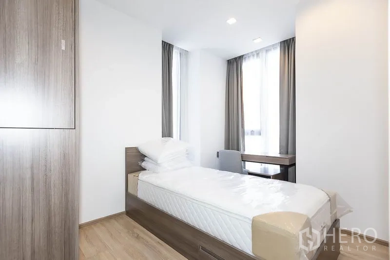 公寓 出租在Phaya Thai, Bangkok - 次卧带单人床、内置衣柜与窗边书桌，木质地板。