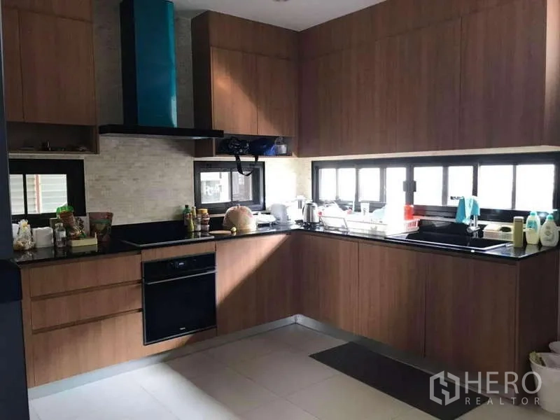 Detached House for rent in Bang Phli, Samut Prakan - U-shaped kitchen with wood cabinetry, black stone countertops and windows