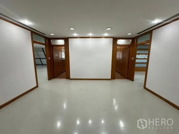 办公空间 出租在Phaya Thai, Bangkok - 接待区或前厅，中央白色背景墙，两侧为木框门洞。