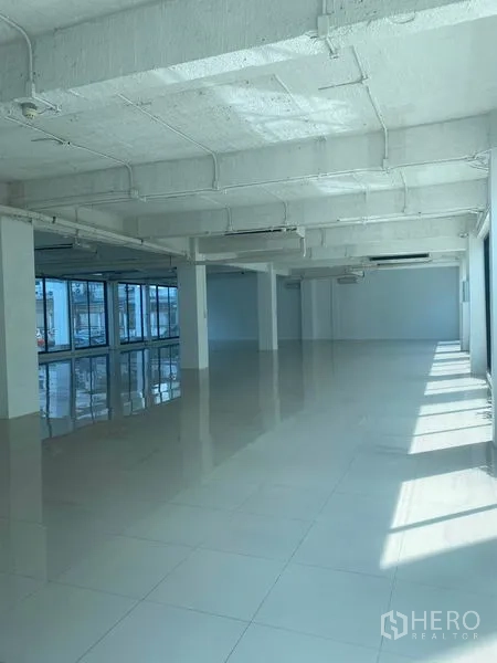 办公空间 出租在Khlong Toei, Bangkok - 开放办公区，成排窗户引入阳光，外露管线天花与亮面地面。
