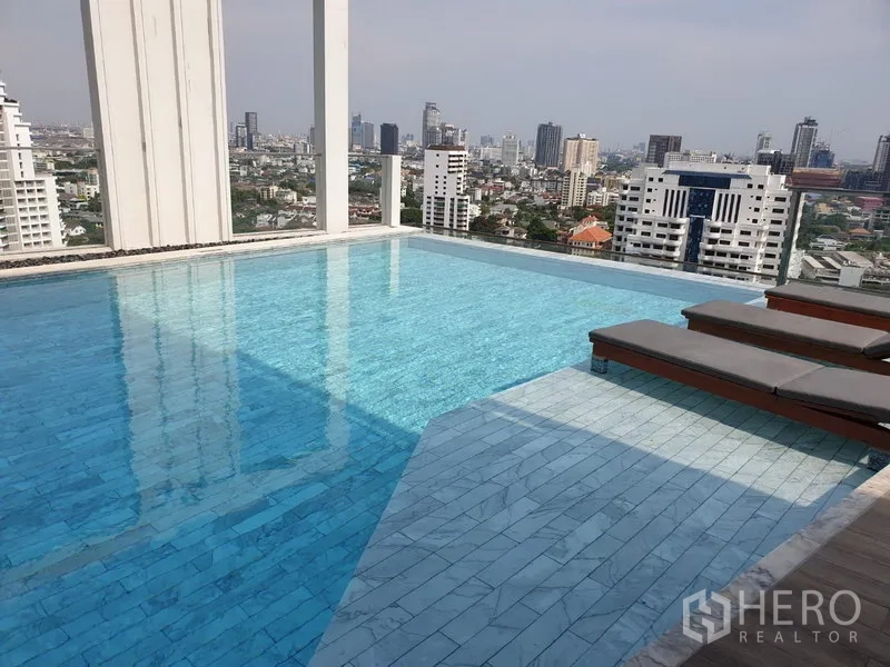 公寓 出租在Watthana, Bangkok - 屋顶无边际泳池配躺椅，俯瞰曼谷天际线。