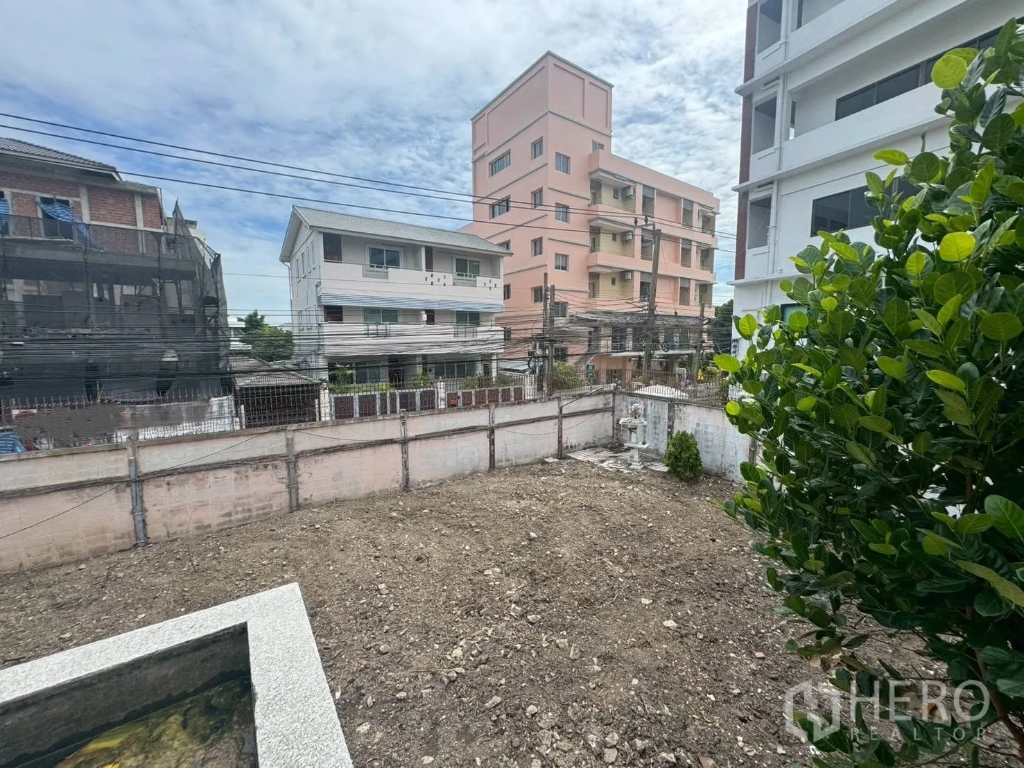 独栋房屋 for rent or sale in Watthana, Bangkok - 从楼上俯瞰清理后的空地与邻近低层建筑景观。