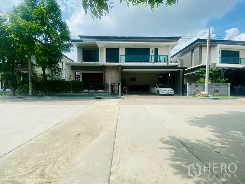 独立式住宅 出租在Prawet, Bangkok - 现代两层独栋别墅外观，带有遮棚停车位与安静街景。