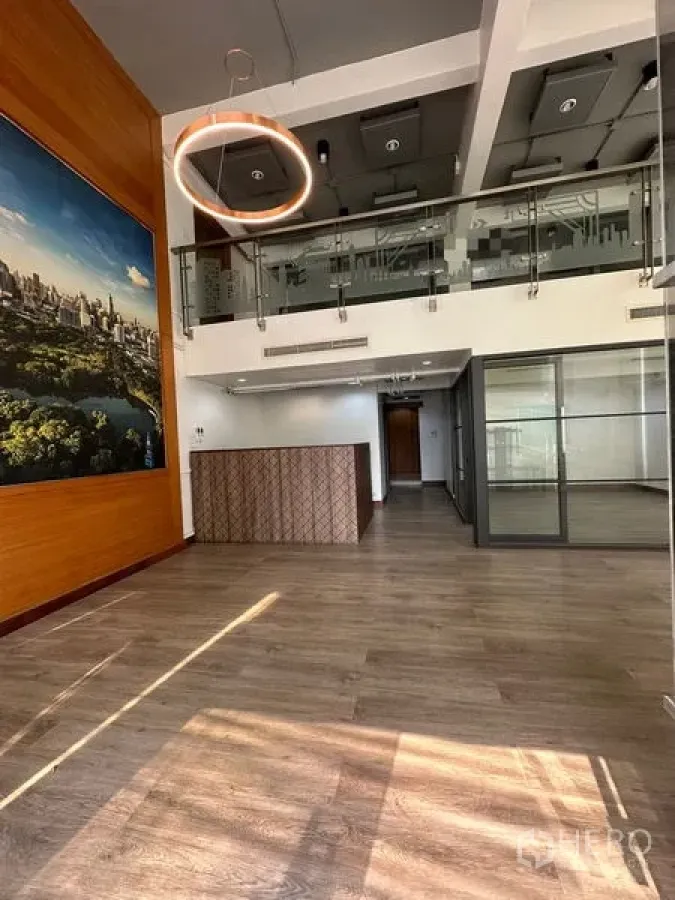 办公空间 出租在Pathum Wan, Bangkok - 接待区带木质装饰、巨幅墙面艺术与夹层玻璃栏杆。