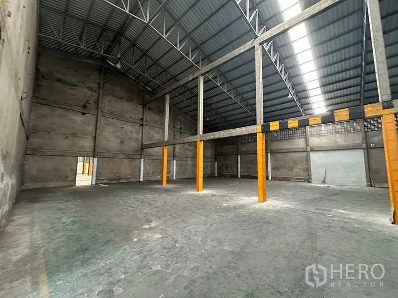 คลังสินค้า ให้เช่าในMueang Pathum Thani, Pathum Thani - พื้นโกดังโล่ง เพดานสูง เสาทาสีทำเครื่องหมายความปลอดภัย.