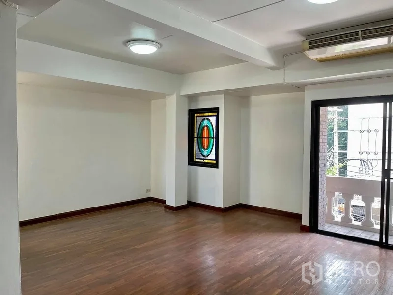 Home Office for rent in Khlong Toei, Bangkok - Bright open workspace with wood flooring, a stained-glass feature window and sliding door to a balcony.