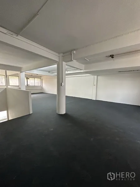 Shophouse for rent in Bang Na, Bangkok - Expansive upper level with columns, low ceiling, and open-plan layout.