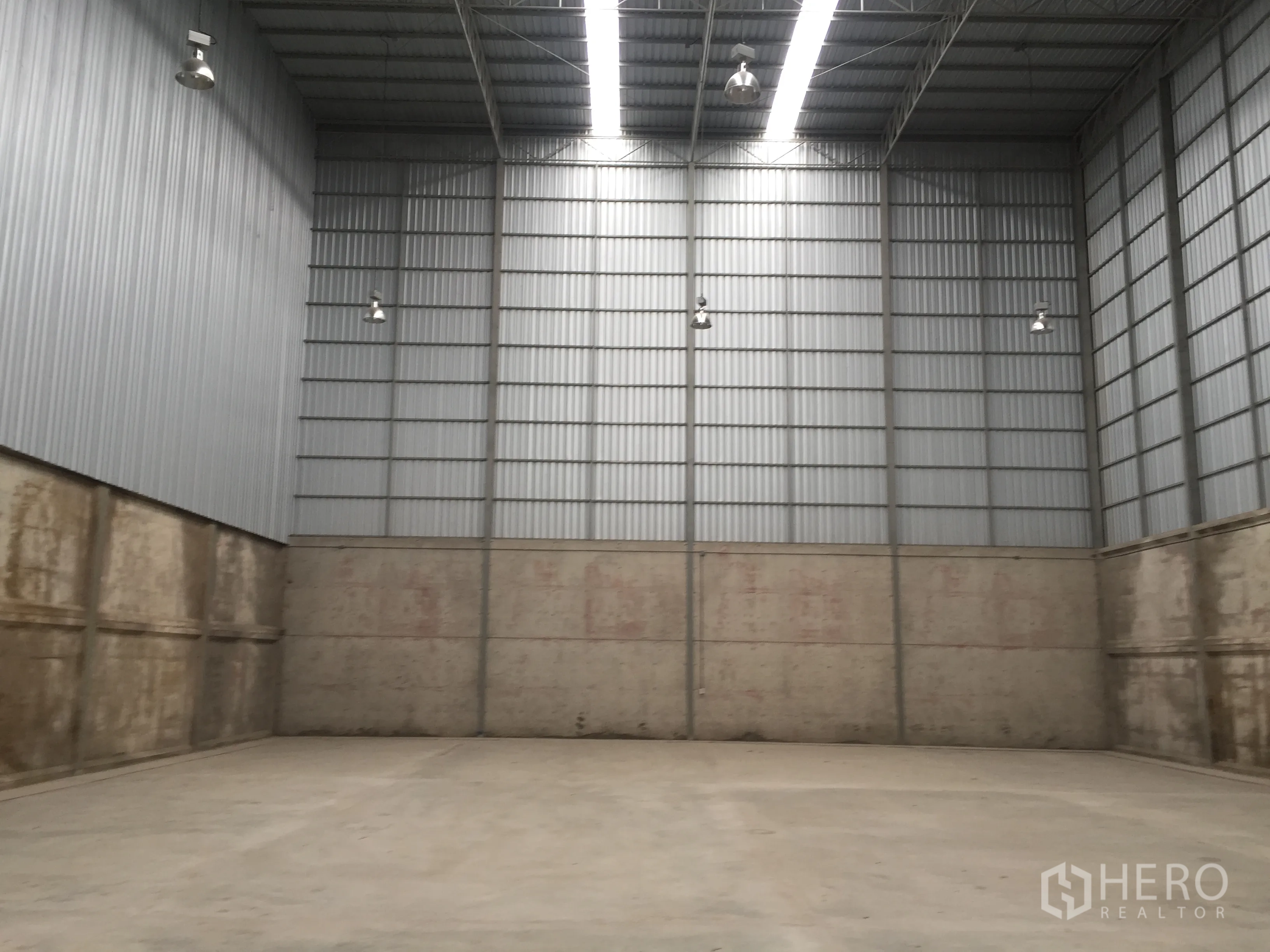 Warehouse for rent in Lam Luk Ka, Pathum Thani - Spacious warehouse interior with 12–16 m high steel ceiling, concrete floor and high-bay lights.