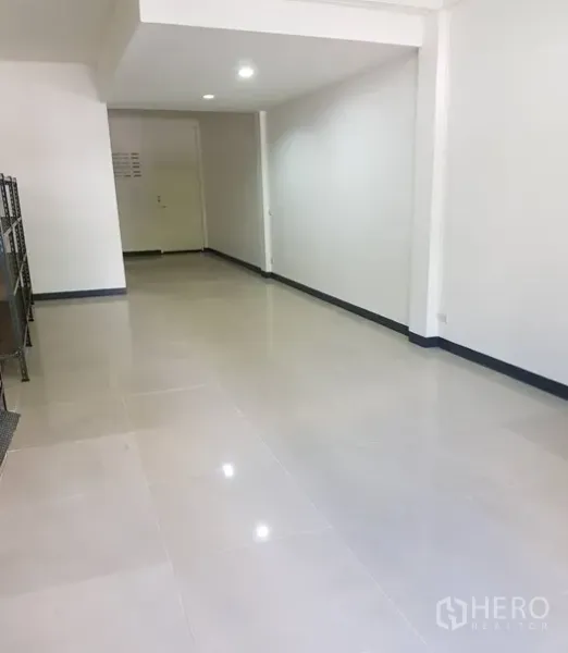 Shophouse for rent in Watthana, Bangkok - Open-plan ground floor with glossy tiled flooring, white walls and recessed lights.