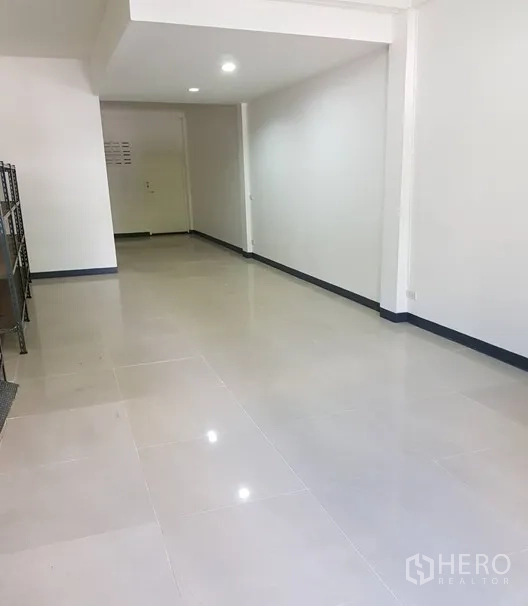 Shophouse for rent in Watthana, Bangkok - Open-plan ground floor with glossy tiled flooring, white walls and recessed lights.