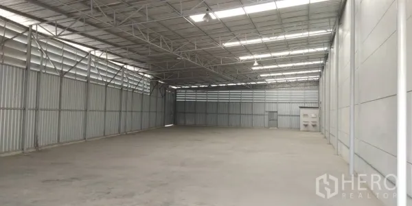 Warehouse for rent in Lam Luk Ka, Pathum Thani - Open-plan warehouse space with a high ceiling, ventilation louvers and ample clear floor area for loading and storage.