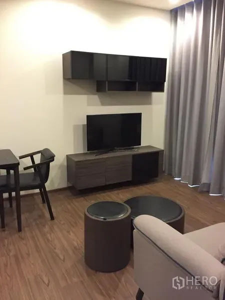 Condominium for rent in Watthana, Bangkok - Another angle of the living area showing TV unit, floating cabinets and full‑height curtains.