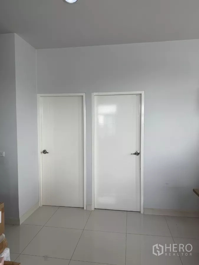 工厂 出售在Lam Luk Ka, Pathum Thani - 室内走廊，白色双门与亮面瓷砖地坪。