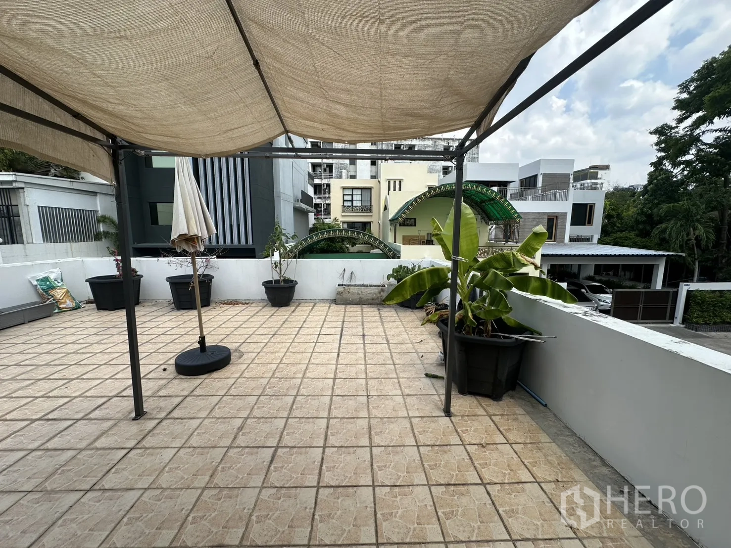 Detached House for rent in Watthana, Bangkok - Rooftop terrace with canopy and planter boxes overlooking neighboring homes.