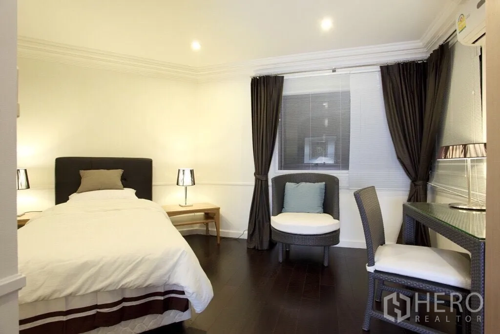 Condominium for rent in Sathon, Bangkok - Guest bedroom with single bed, study desk, and seating area by the window.