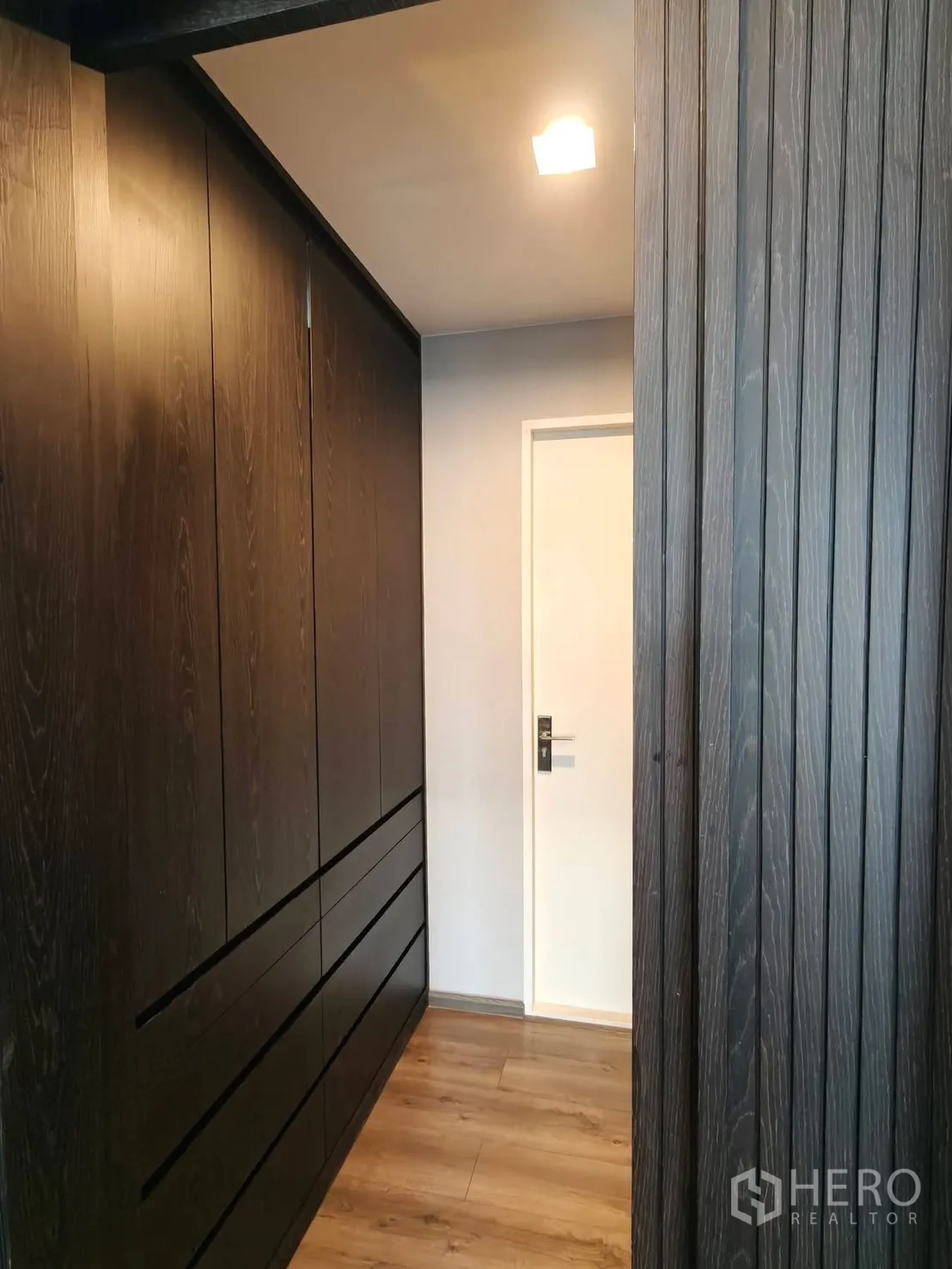 บ้านเดี่ยว for rent or sale in Bang Phli, Samut Prakan - โถงทางเดินพร้อมตู้เสื้อผ้าบิวท์อินสีไม้เข้มและลิ้นชัก.
