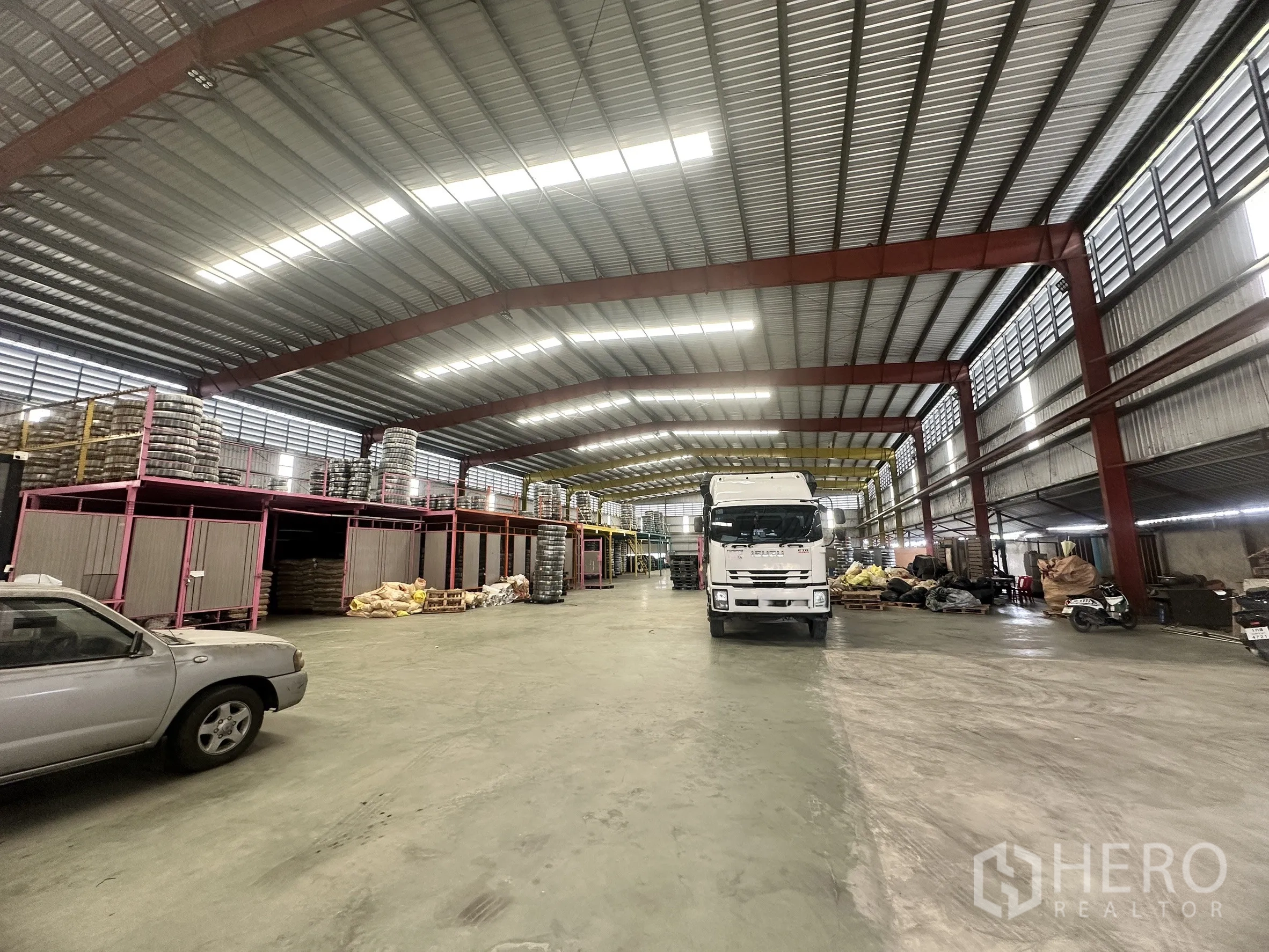 仓库 for rent in Mueang Samut Prakan, Samut Prakan - 开阔仓库地面，卡车可进入，夹层货架与屋顶照明明显。