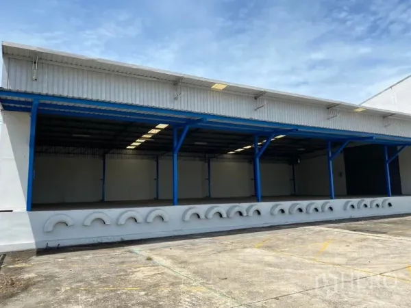 โรงงาน ให้เช่าในNonthaburi - ชานโหลดสินค้ามีหลังคา เสาโครงเหล็กสีน้ำเงิน และพื้นยกสูงของโรงงาน