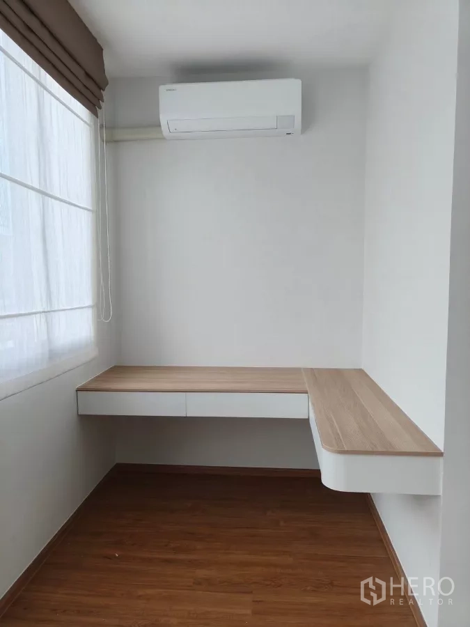 Townhouse for rent in Bang Phli, Samut Prakan - Sunny multipurpose room with L-shaped work desk, drawers and air conditioner.