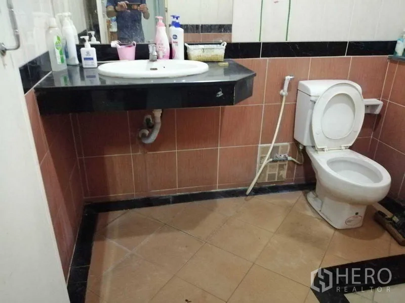 独立式住宅 出售在Prawet, Bangkok - 第二间浴室，棕色地砖、洗手台与马桶。