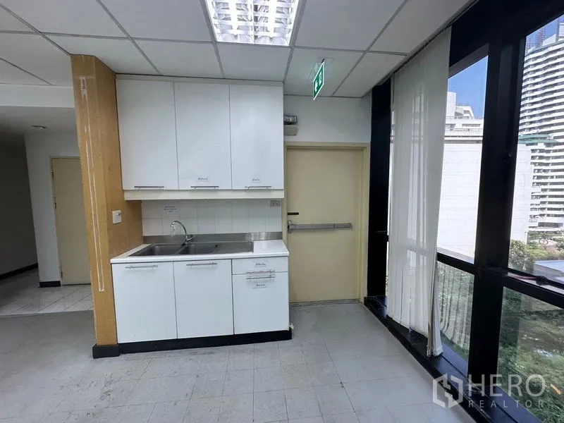 办公空间 出租在Khlong Toei, Bangkok - 办公室内带茶水间，水槽与白色橱柜，临近大窗