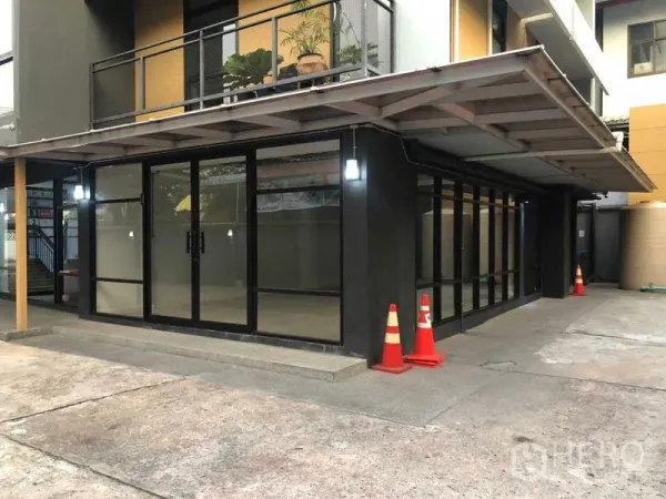 Office Space for rent in Phaya Thai, Bangkok - Side view of glass-walled corner office with walkway and safety cones.