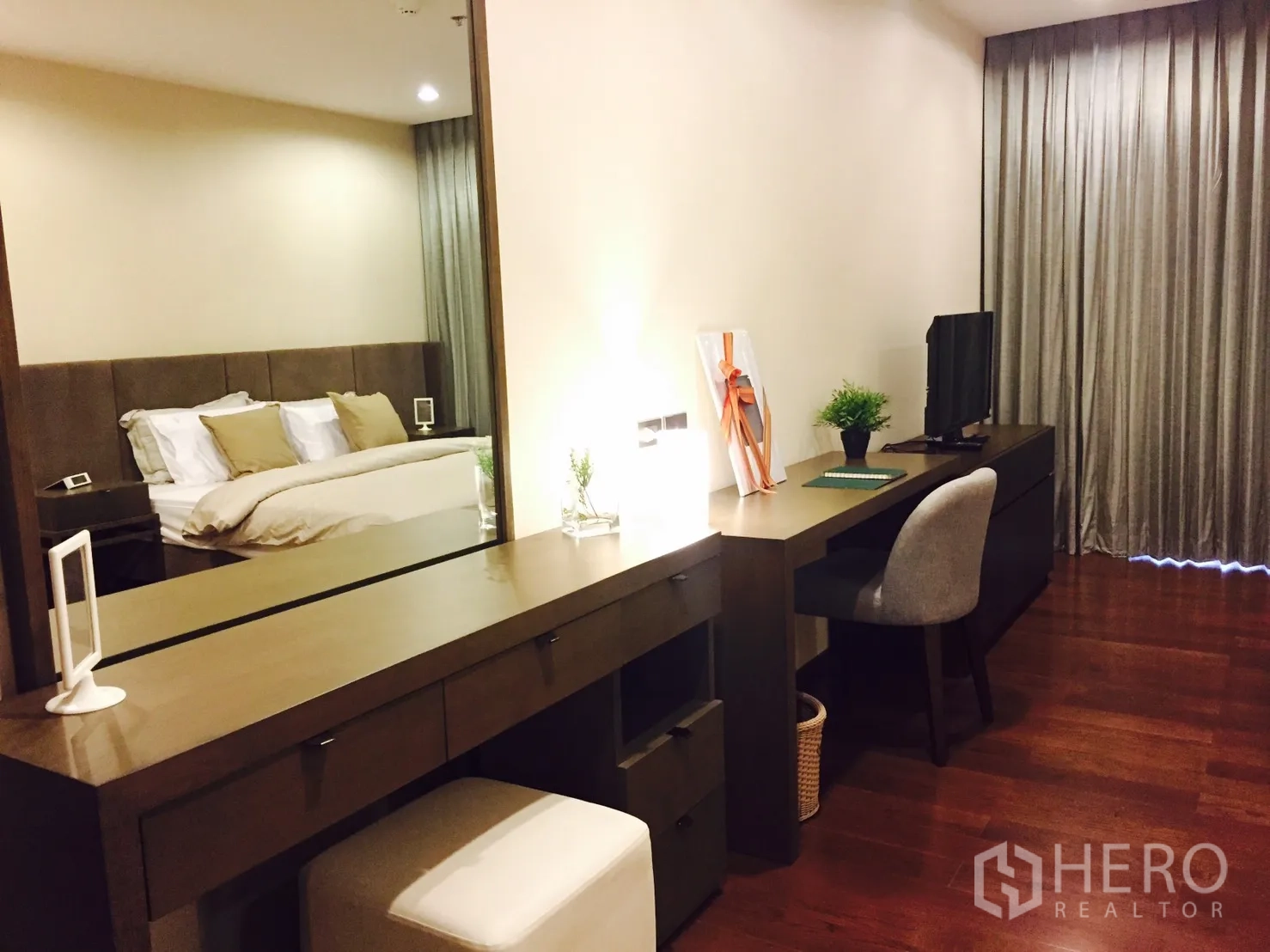 Condominium for rent or sale in Sathon, Bangkok - Long vanity and work desk with mirror, TV, and chair in the master suite.