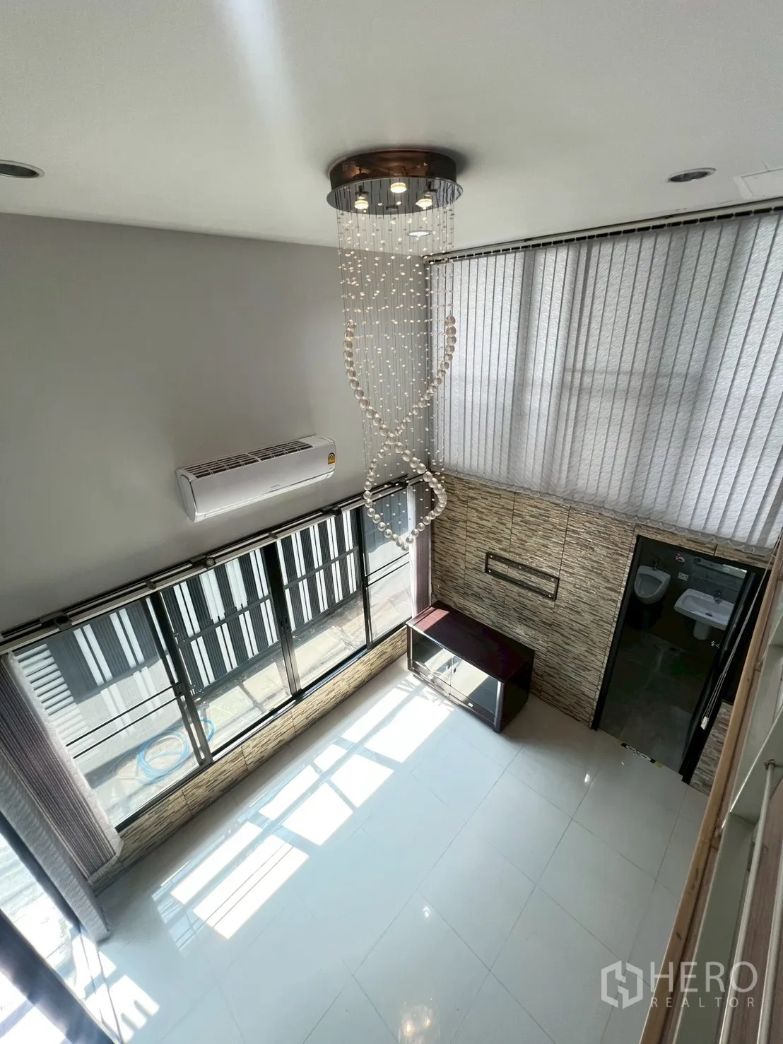 Detached House for rent or sale in Wang Thonglang, Bangkok - Double‑height living area with large windows and a modern chandelier.