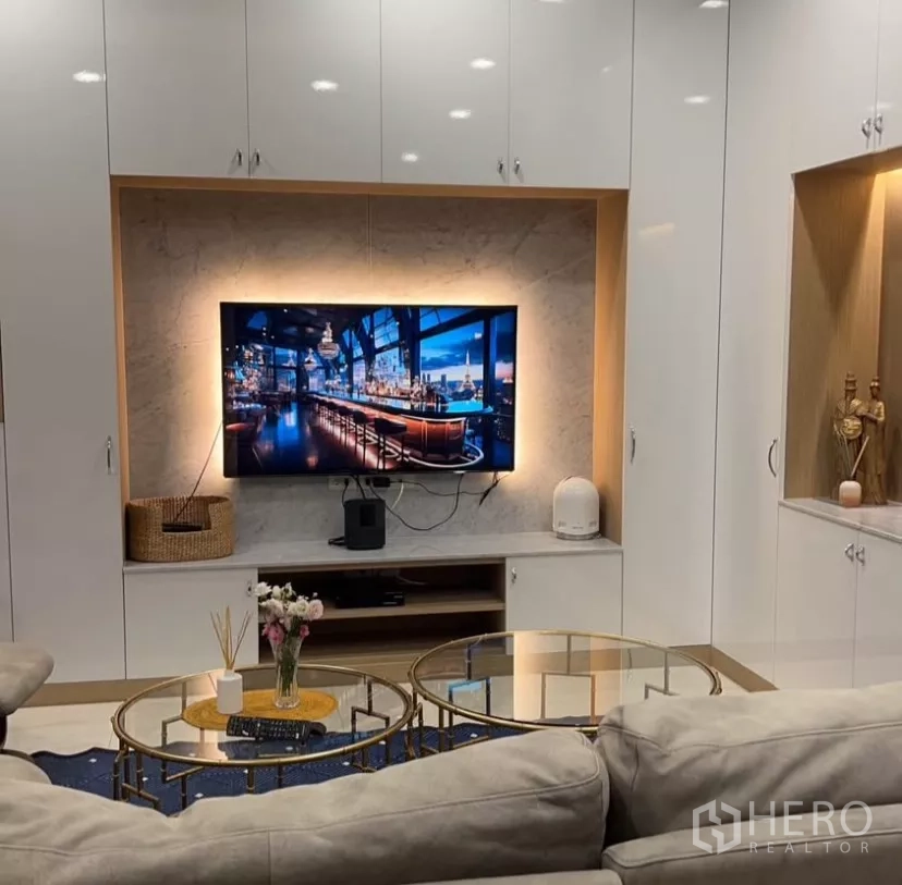 Townhouse for rent in Yan Nawa, Bangkok - Backlit TV feature wall with marble surround and glass coffee tables.
