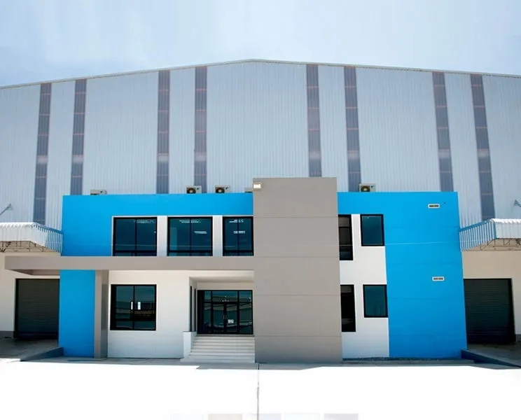 货栈 出租在Chachoengsao - 现代化仓库外立面，蓝灰色办公楼体与大型卷帘门。
