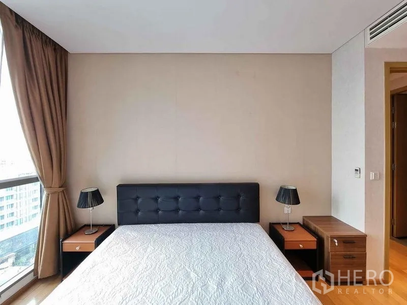 公寓 出租在Watthana, Bangkok - 主卧配软包床头与床头柜，靠窗布局。