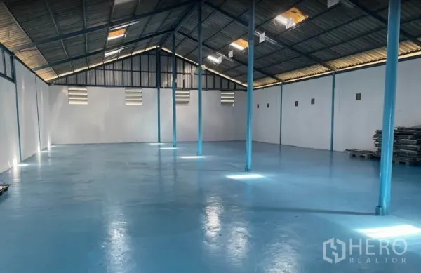 Warehouse for rent in Bang Pa-in, Phra Nakhon Si Ayutthaya - Spacious 400 sqm warehouse interior with blue epoxy floor, steel columns, skylights and wall vents in Bang Pa-in.