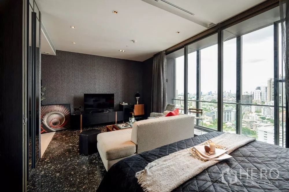 Condominium for rent or sale in Khlong Toei, Bangkok - Open-plan sleeping area facing the living room with TV console and panoramic city window.
